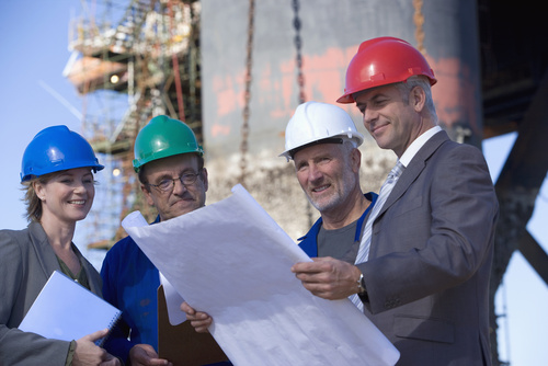 4 workers looking at plans